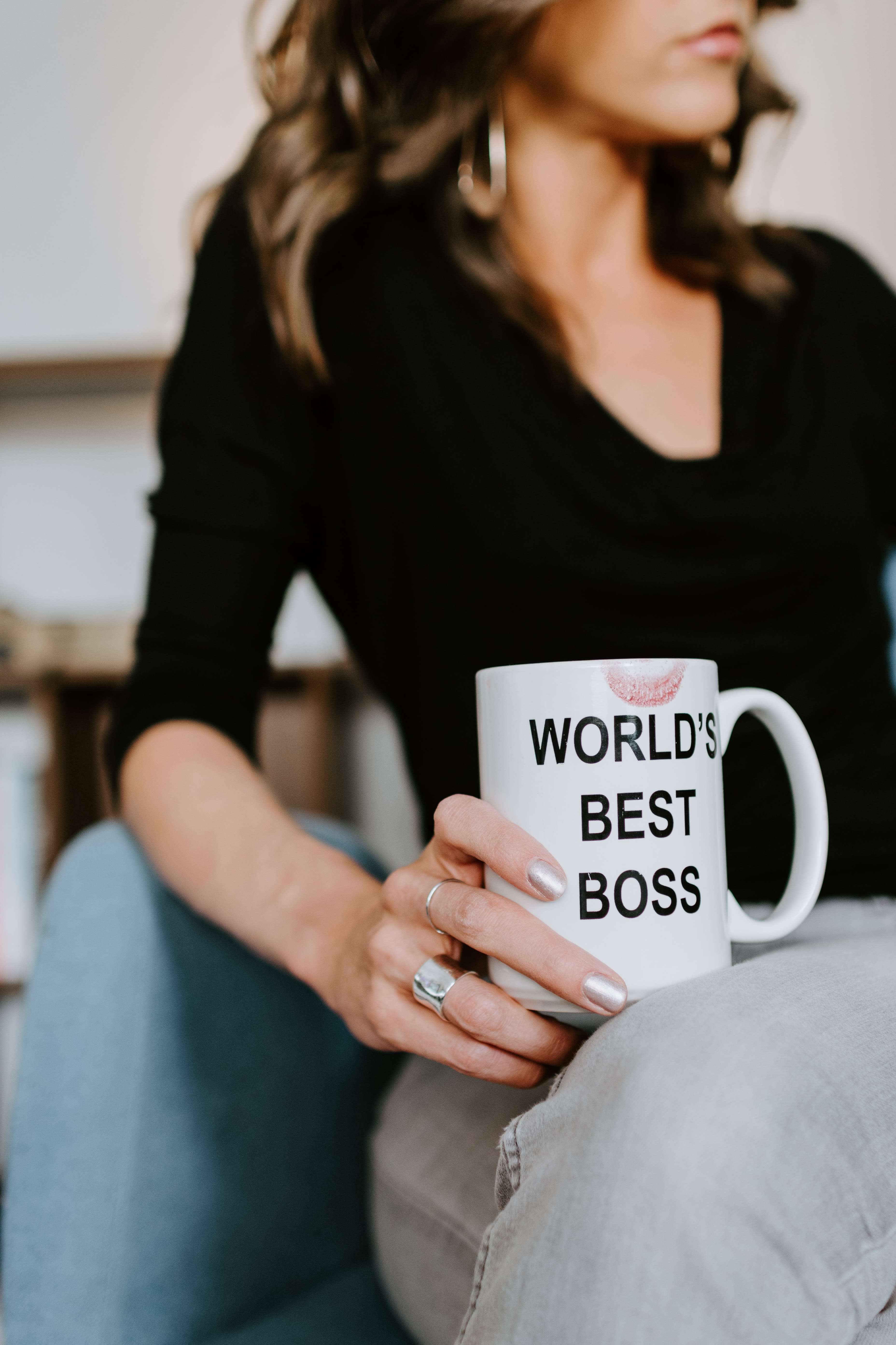 Woman in black long sleeve shirt holding white ceramic mug